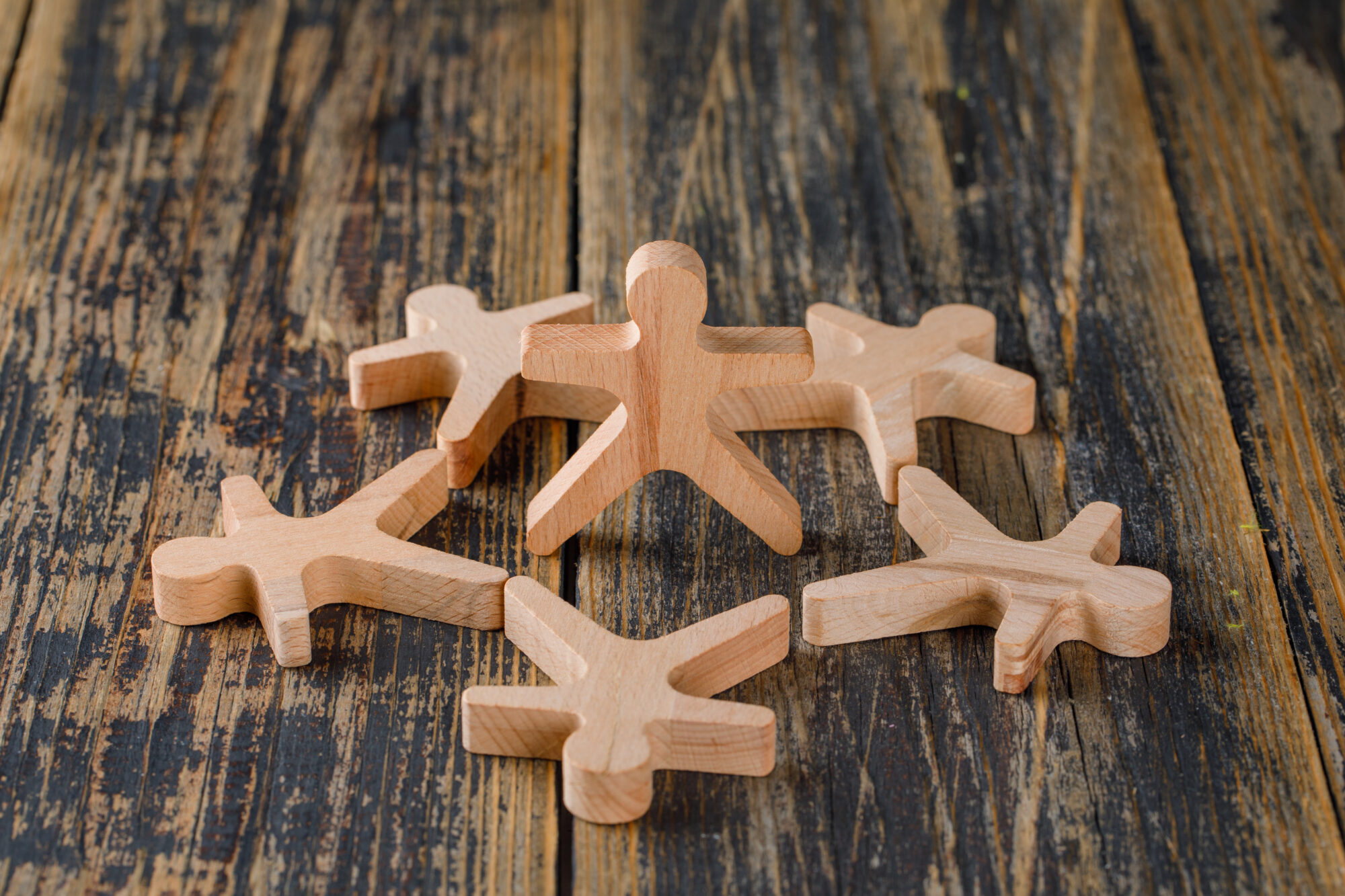 NOS VALEURS - Business success concept with wooden figures of people on wooden background high angle view.